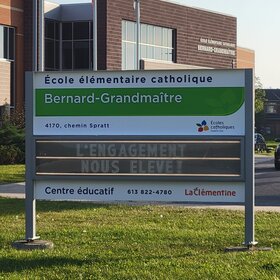 Affiche devant l'école sur laquelle on peut lire : L'engagement nous élève